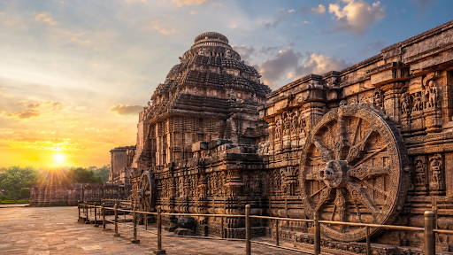 Carved stone chariot wheel of the Konark Sun Temple at sunset