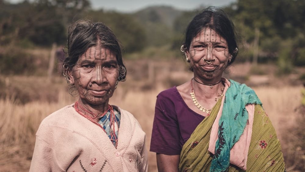 Two tribal women with traditional facial tattoos in rural Odisha